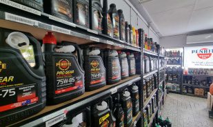 Rack full of engine oils inside the store - General Services - Taylored Automotive